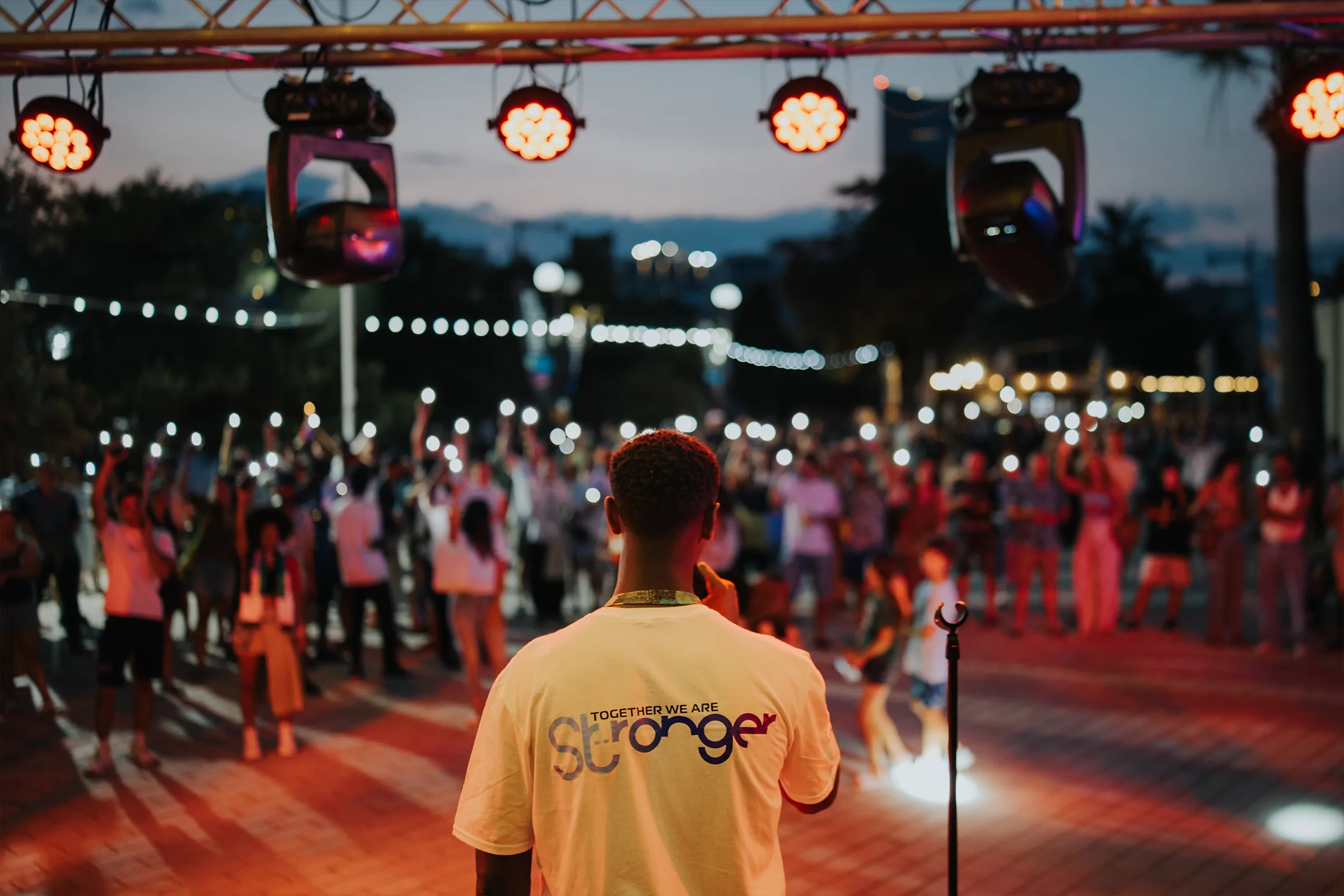 Guests gathering at the TVMSport Euro 2024 Fan Village beneath Mercury’s illuminated buildings.