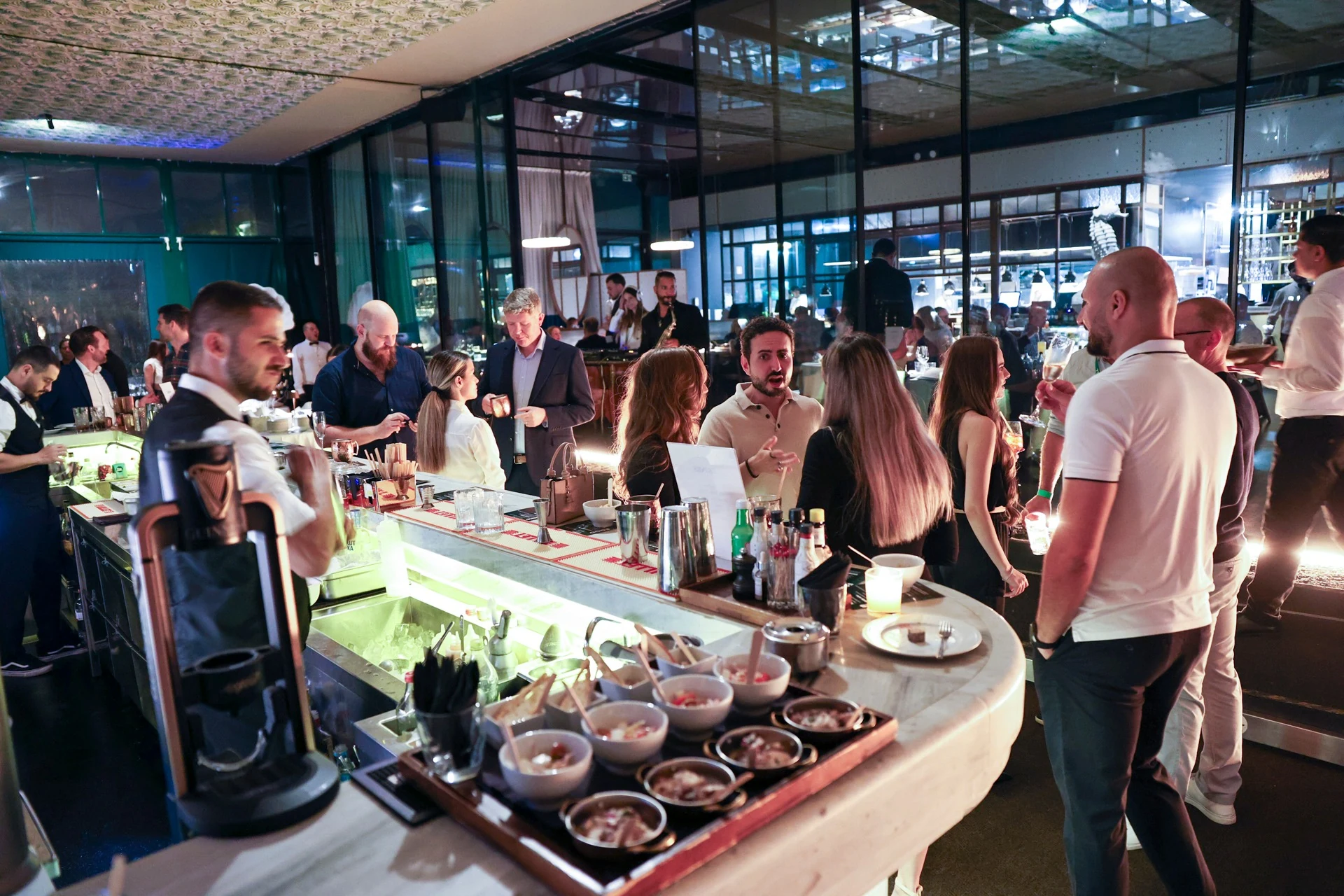 Guests in conversation around the illuminated bar at Altitude × EveryMatrix, Lisbon 2026.